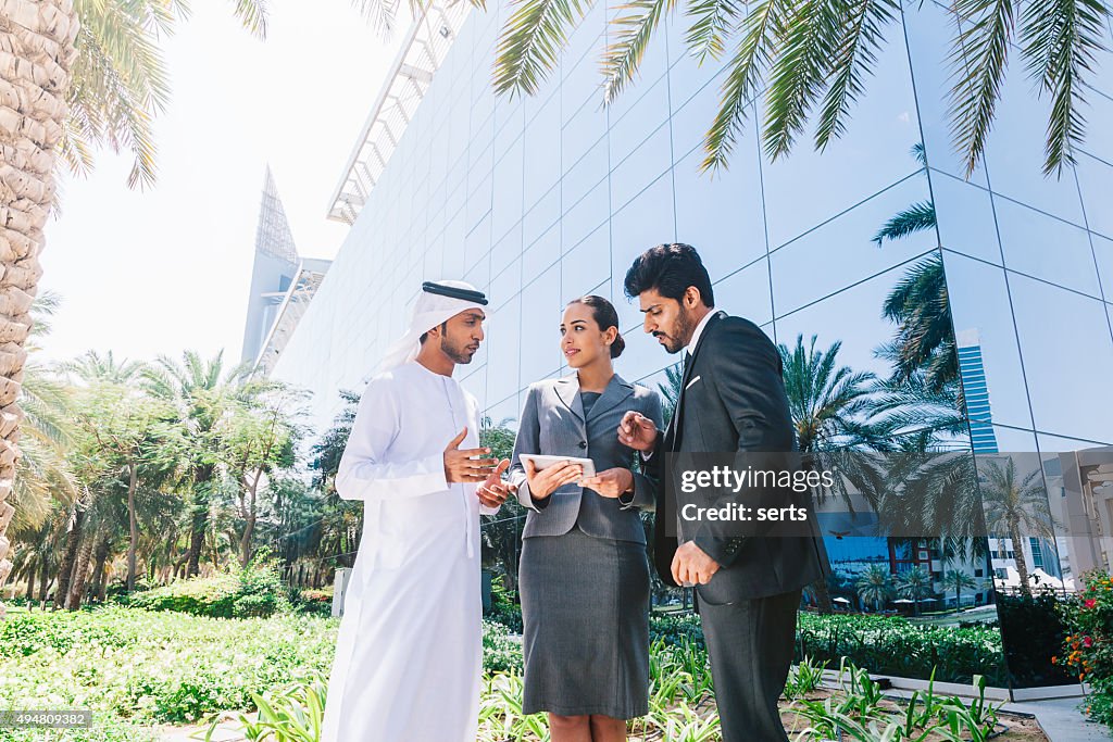 Middle Eastern Businessmen and Businesswoman working with Digital Tablet Outdoor