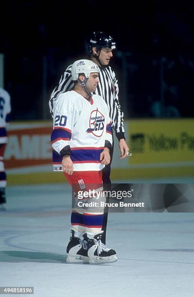 Tie Domi of the Winnipeg Jets is escorted to the penalty box after a fight during an NHL game against the Calgary Flames on January 20, 1995 at the...