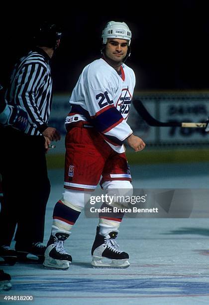 Tie Domi of the Winnipeg Jets is escorted to the penalty box after a fight during an NHL game in March, 1995 at the Winnipeg Arena in Winnipeg,...