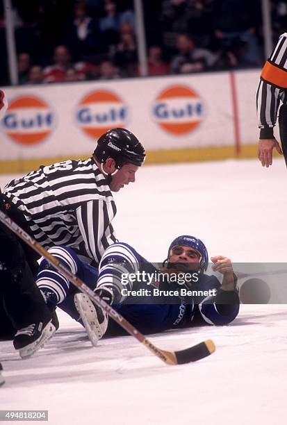 Tie Domi of the Toronto Maple Leafs lays on the ice as a linesman holds him down after a fight against the New Jersey Devils on January 31, 1997 at...