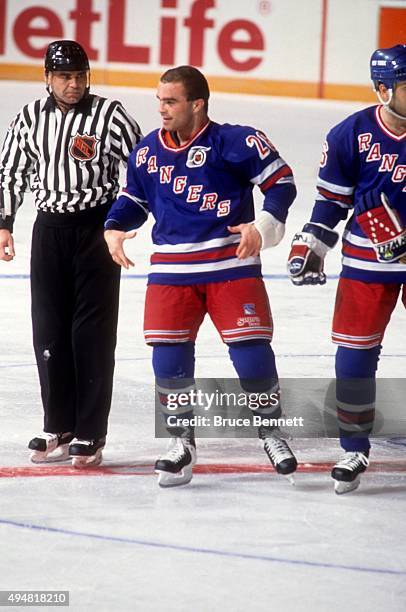 Tie Domi of the New York Rangers is escorted to the penalty box after a fight during an NHL game against the Detroit Red Wings on February 9, 1992 at...