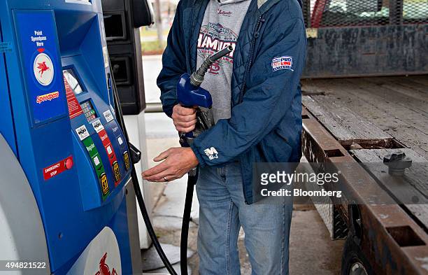 Customer fills up a vehicle with fuel at an Exxon Mobil Corp. Gas station in Rockford, Illinois, U.S., on Wednesday, Oct. 28, 2015. Exxon Mobil Corp....
