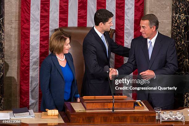 Incoming speaker Rep. Paul Ryan, R-Wis., shakes hands with outgoing Speaker John Boehner, R-Ohio, as House Minority Leader Nancy Pelosi, D-Calif.,...