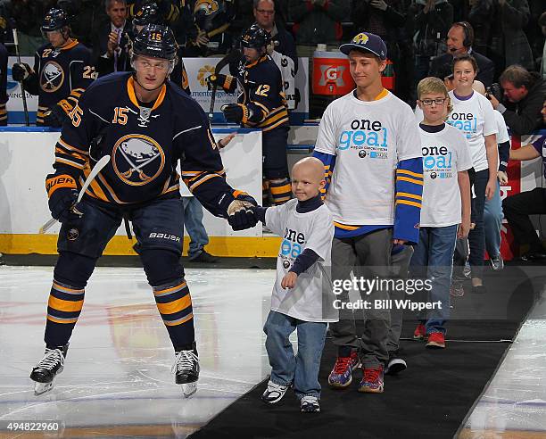 Carly's Club member Matthew Eggers is escorted on the ice by Jack Eichel of the Buffalo Sabres prior to their NHL game against the New Jersey Devils...