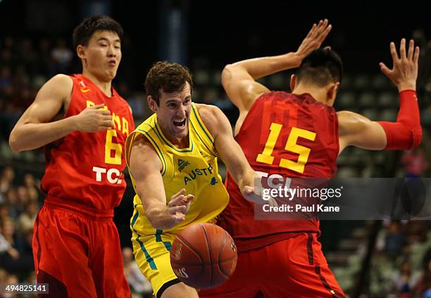 Ben Madgen of Australia passes the ball against Quan Gu and Zhonghao Xu of China during the 2014 Sino-Australia Challenge match between the...