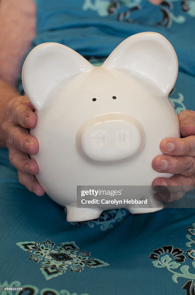 Elderly Lady Holding Piggy Bank
