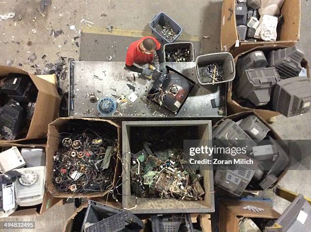 An employee dismantles televisions as they further await to be dismantled as recyclable waste at the Electronic Recyclers International plant in...