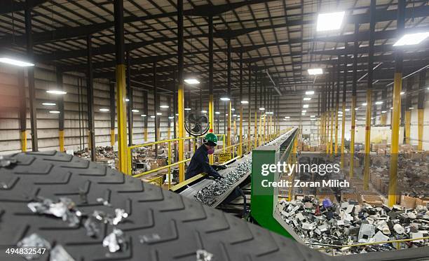 An employee culls bad parts out of crushed metal recyclable waste at the Electronic Recyclers International plant in Holliston, Massachusetts, USA.