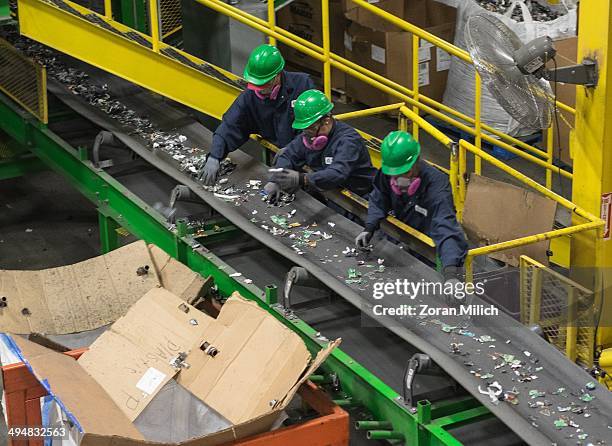 Assembly line workers examine dismantled and crushed recyclable waste at the Electronic Recyclers International plant in Holliston, Massachusetts,...