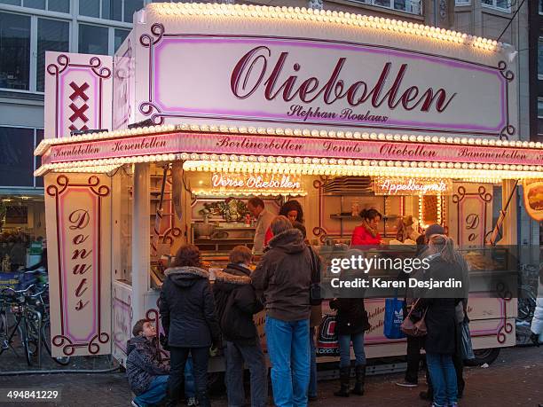 An outdoor stand in central Amsterdam selling oliebollen, a snack similar to a donut, but without a hole in the center. Oliebollen are a traditional...