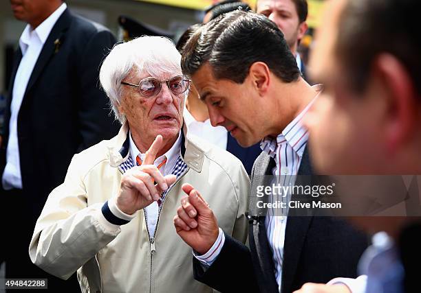 Supremo Bernie Ecclestone walks with the President of Mexico, Enrique Pena Nieto in the pit lane during previews to the Formula One Grand Prix of...