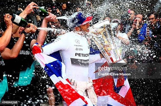 Lewis Hamilton of Great Britain and Mercedes GP celebrates with the team in the pit lane after winning the United States Formula One Grand Prix and...
