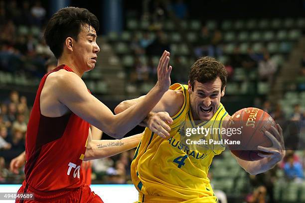 Ben Madgen of Australia drives to the basket against Fei Cao of China during the 2014 Sino-Australia Challenge match between the Australian Boomers...