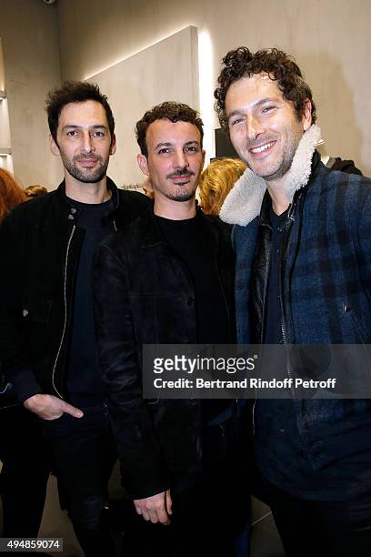 Calligrapher Nicolas Ouchenir standing between Members of Musical Group Aaron, Olivier Coursier and Simon Buret attend the Opening of the Collection...