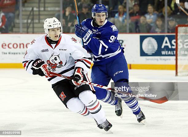 Luke Kutkevicius of the Mississauga Steelheads and Mikkel Aagaard of the Niagara IceDogs skate during an OHL game at the Meridian Centre on October...