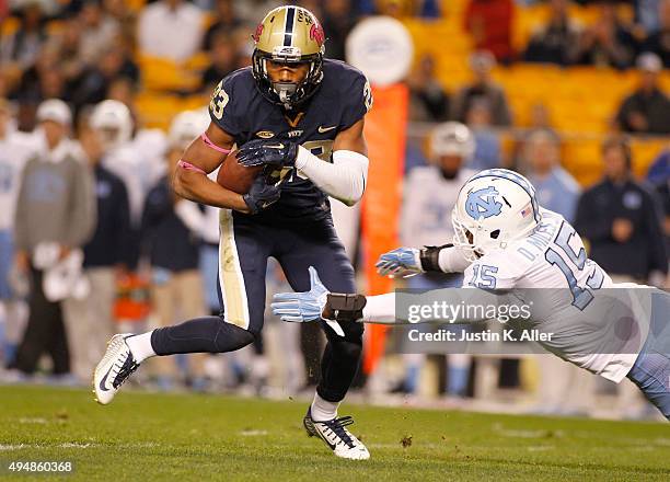 Tyler Boyd of the Pittsburgh Panthers runs after making a catch in the first half during the game against Donnie Miles of the North Carolina Tar...