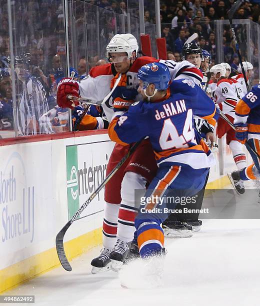 Calvin de Haan of the New York Islanders rides Eric Staal of the Carolina Hurricanes into the boards during the third period at the Barclays Center...