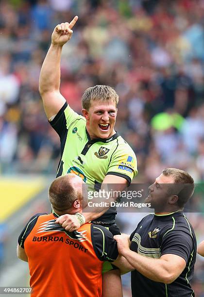 Alex Waller of Northampton Saints is lifted up by team mates after scoring the winning try in extra time during the Aviva Premiership Final between...