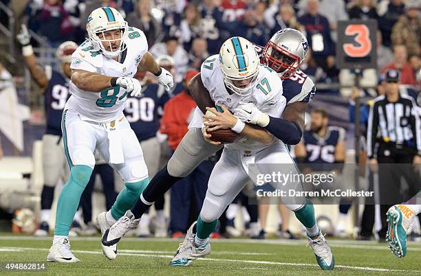 Ryan Tannehill of the Miami Dolphins is sacked by Chandler Jones of the New England Patriots during the second quarter at Gillette Stadium on October...