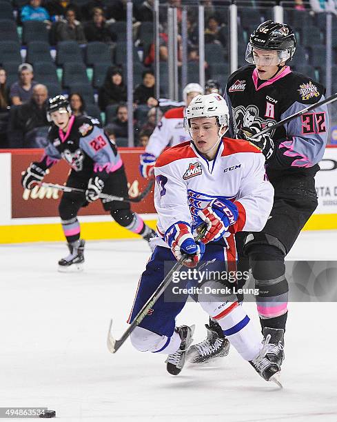 Travis Sanheim of the Calgary Hitmen checks Kailer Yamamoto of the Spokane Chiefs during a WHL game at Scotiabank Saddledome on October 29, 2015 in...