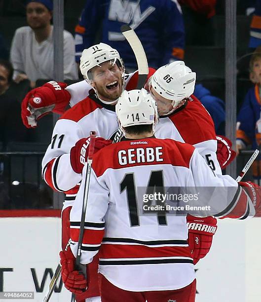 Ron Hainsey of the Carolina Hurricanes celebrates his game winning goal at 2:21 of the overtime against the New York Islanders along with Jordan...