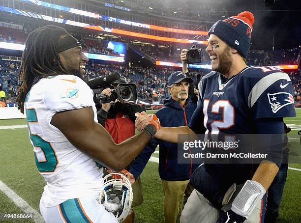 Tom Brady of the New England Patriots high fives Walt Aikens of the Miami Dolphins after a game at Gillette Stadium on October 29, 2015 in Foxboro,...