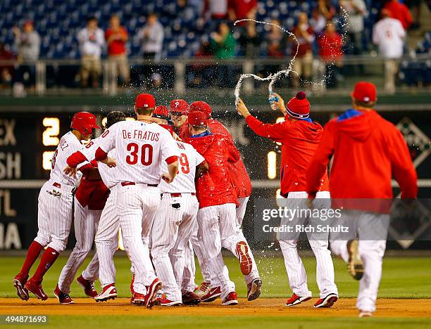 Reid Brignac the Philadelphia Phillies is mobbed by teammates after hitting the game winning single in the fourteenth inning to defeat the New York...