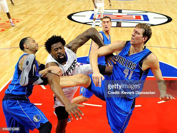 DeAndre Jordan of the Los Angeles Clippers is fouled by Dirk Nowitzki and Devin Harris of the Dallas Mavericks during the second quarter of the...