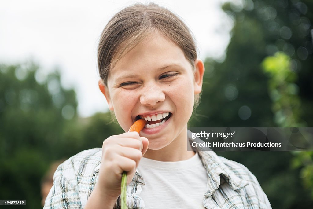 Young Girl Eating Fresh Carrot