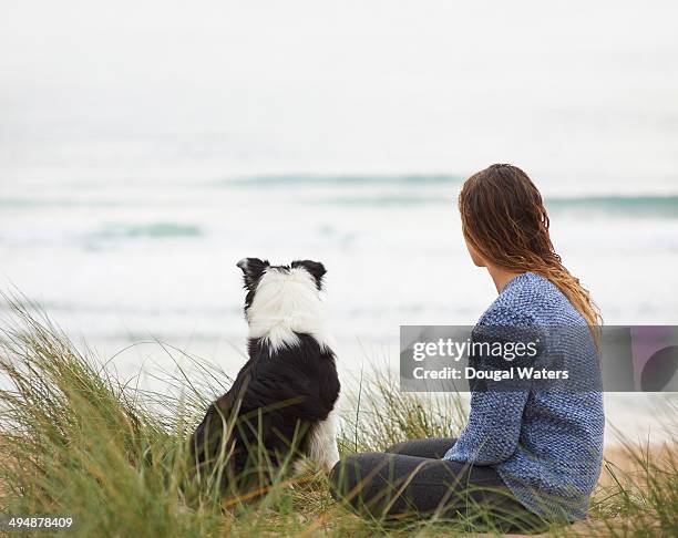 woman and dog look out to sea. - dougal waters 個照片及圖片檔