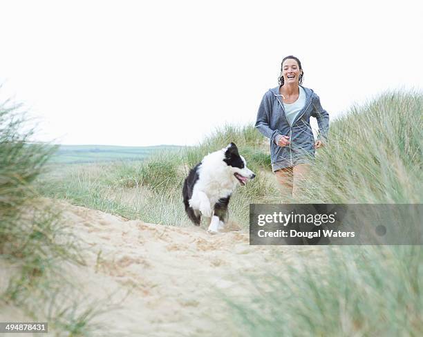 woman walking dog at beach. - dog walking fotografías e imágenes de stock