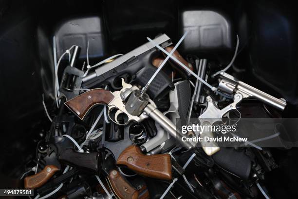 Surrendered handguns are piled in a bin during a gun buyback event that was announced by Los Angeles Mayor Eric Garcetti in the wake of a killing...