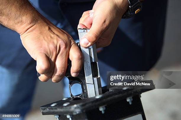 Police officer clears a surrendered Jennings Nine 9mm handgun at a gun buyback event that was announced by Los Angeles Mayor Eric Garcetti in the...