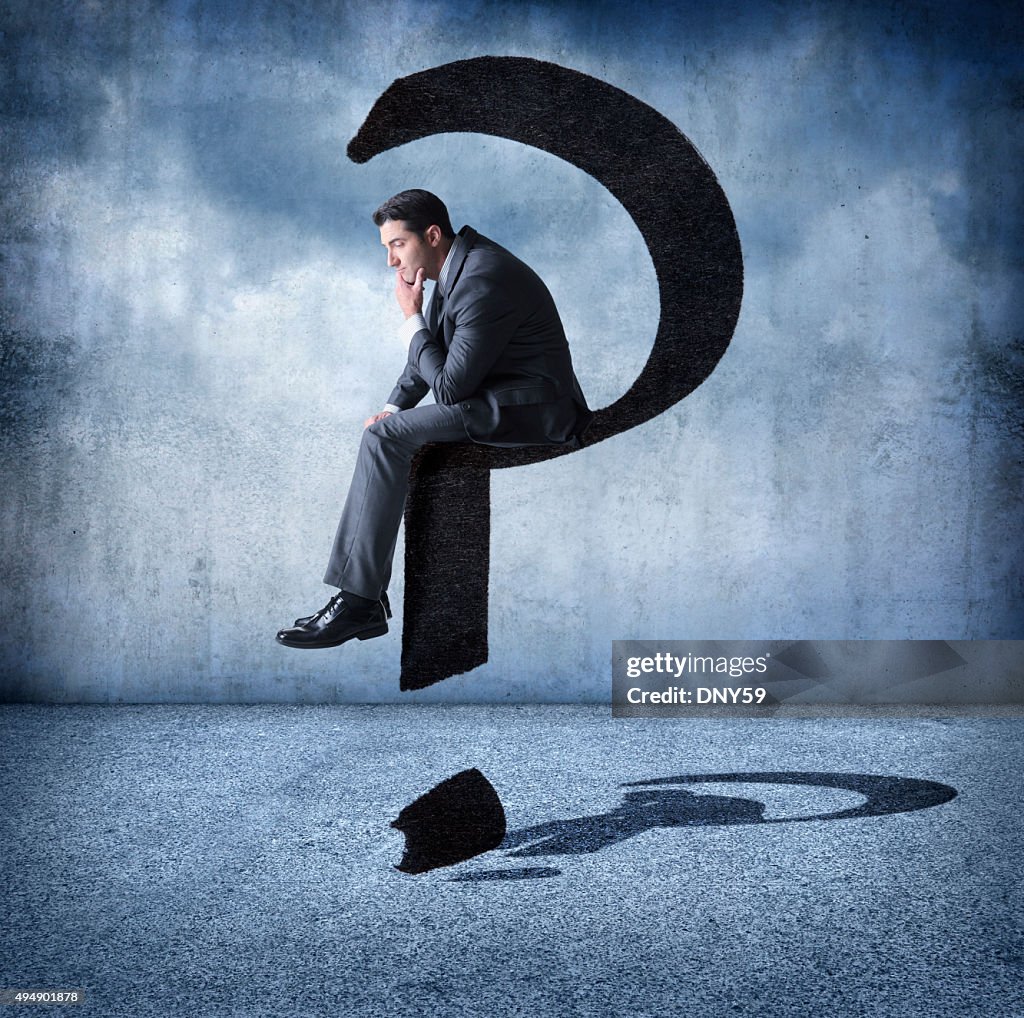 Businessman Sitting On A Floating Question Mark