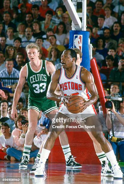 Vinnie Johnson of the Detroit Pistons looks to pass the ball in front of Larry Bird of the Boston Celtics during an NBA basketball game circa 1987 at...