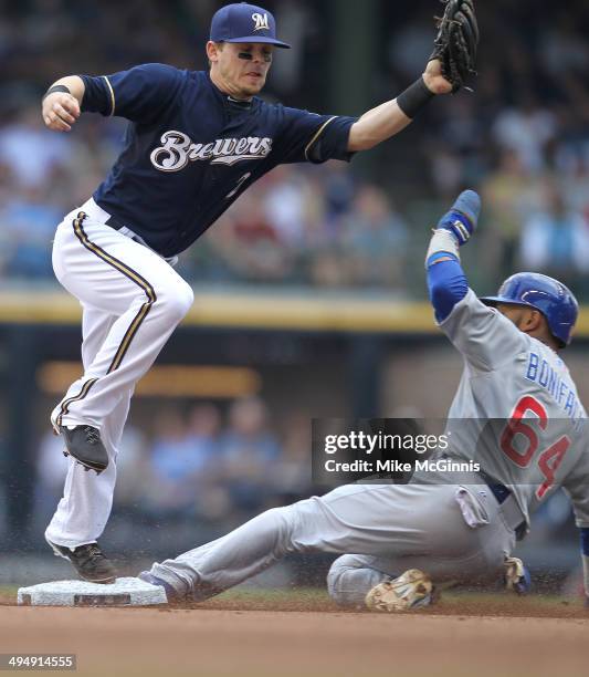 Emilio Bonifacio of the Chicago Cubs beats the throw to Scooter Gennett of the Milwaukee Brewers during the top of the fourth inning against the...