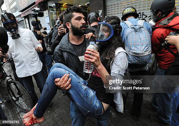 Man holds an injured and bleeding woman protester as Turkish police prevent demonstrators getting to Taksim Square to mark the one-year anniversary...