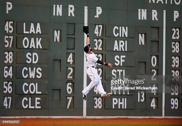 Jonny Gomes of the Boston Red Sox jumps for a fly ball in left field but fails to come up with it in the third inning against the Tampa Bay Rays...