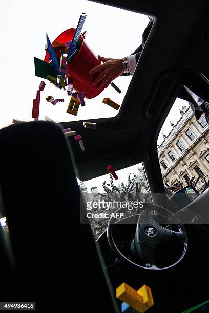 Lego bricks are poured through the sunroof of a BMW 5 series car, used as a receptacle for donations of Lego bricks in the courtyard of the Royal...