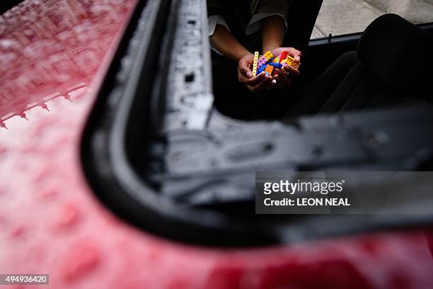 Woman holds Lego bricks inside a BMW 5 series car, used as a receptacle for donations of Lego bricks in the courtyard of the Royal Academy in central...
