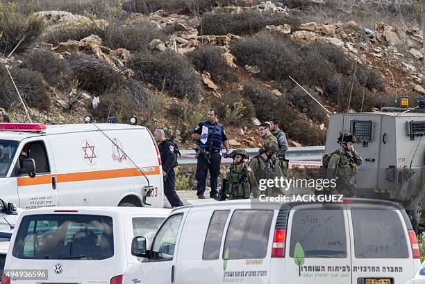 Israeli security forces gather next to the body of a Palestinian man who was shot dead after allegedly trying to stab Israeli police at the Tapuah...