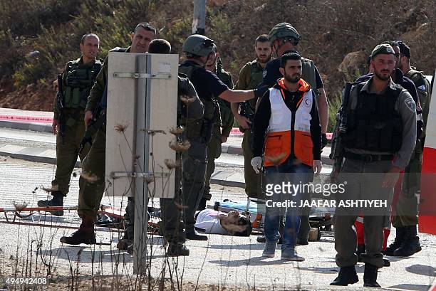 Israeli security forces and emergency personnel stand next to the body of a Palestinian man who was shot dead after allegedly trying to stab Israeli...