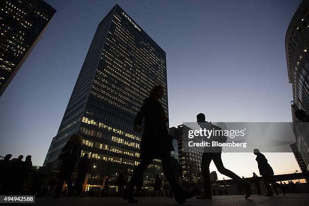 Commuters walk past the JP Morgan building in the Canary Wharf business, financial and shopping district of London, U.K., on Wednesday, Oct. 28,...