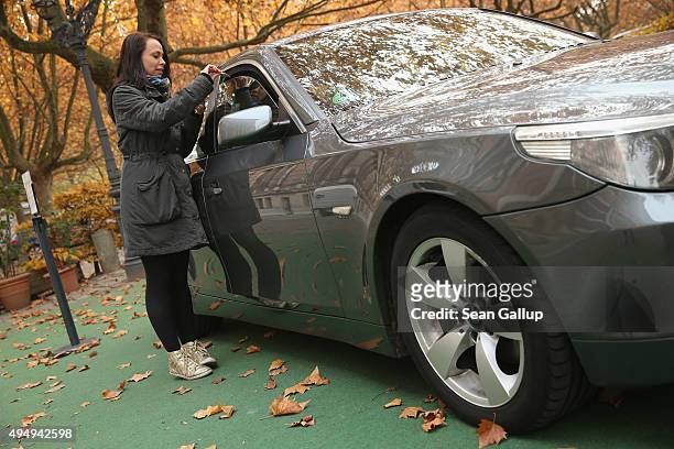 Passerby Lena Lauschuss drops Lego pieces she brought into a BMW car that is being used as a collection point for Lego donations for Chinese artist...