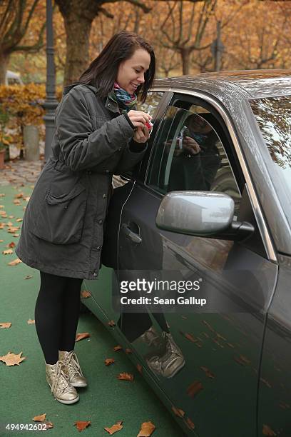 Passerby Lena Lauschuss drops Lego pieces she brought into a BMW car that is being used as a collection point for Lego donations for Chinese artist...