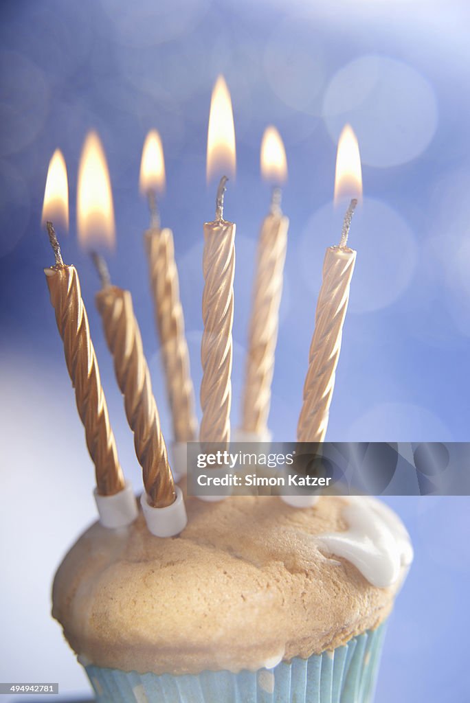 Muffin with golden burning candles