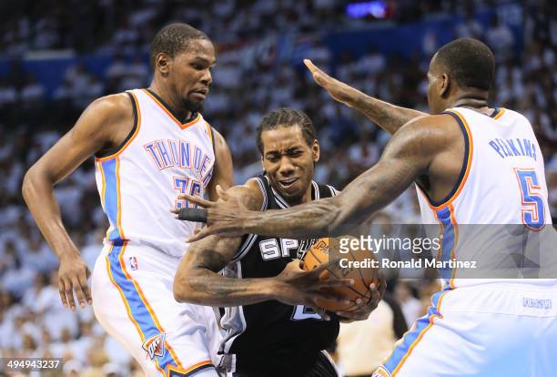 Kevin Durant and Kendrick Perkins of the Oklahoma City Thunder defend against Kawhi Leonard of the San Antonio Spurs in the first half during Game...