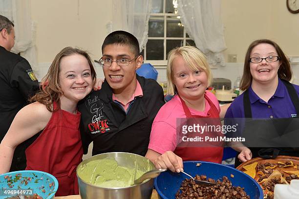 Best Buddies Katie Meade, Michael Jaxtime-Barry, Lauren Potter and Mollie Noble prepare in the kitchen at the after party for the Best Buddies...