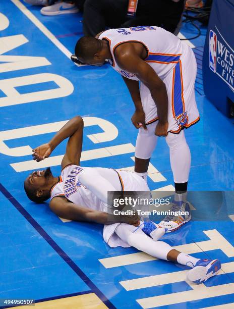 Serge Ibaka of the Oklahoma City Thunder checks on Kevin Durant after he was knocked to the court against the San Antonio Spurs in the second half...