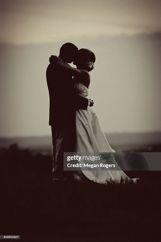 Bride and groom kiss silhouette